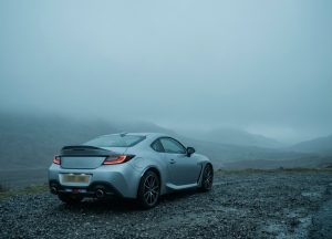 Серебристый автомобиль-купе в тумане